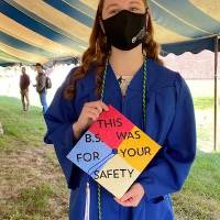 OSH graduate holding "This B.S. was for your safety" graduation cap